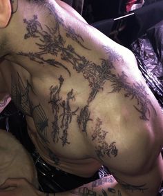 a man with many tattoos on his back