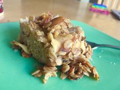 a piece of cake on a green plate with a fork next to it and a can of soda in the background