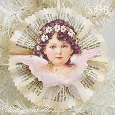 a christmas ornament with an angel on it's head and flowers in her hair