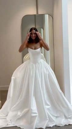 a woman in a wedding dress is taking a selfie