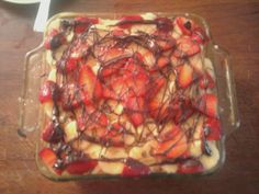 a dessert with strawberries and chocolate drizzled over it on a table