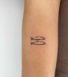 two fish tattoo on the arm