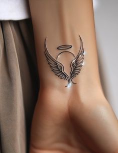 a woman's foot with an angel wing tattoo on the left side of her ankle