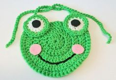 a crocheted green purse with eyes and nose