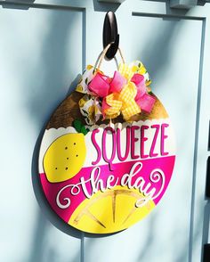 a sign that says squeezeeze the day hanging on a door with pink and yellow flowers