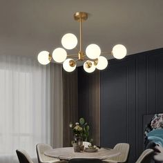 a dining room table with chairs and a chandelier hanging from the ceiling above it