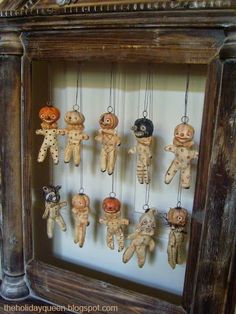 an old wooden frame with many small dolls hanging from it