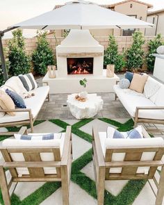 an outdoor living area with white furniture and a fire place