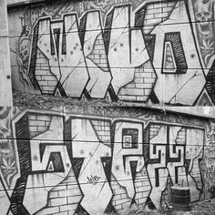 black and white photograph of graffiti on the side of a building