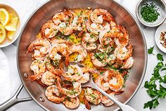 a pan filled with cooked shrimp and garnished with parsley on the side