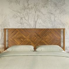 a bed with two nightstands next to it and a wallpapered tree behind it