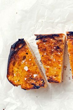 two pieces of bread sitting on top of white paper