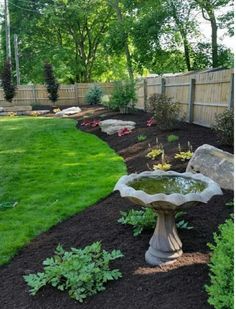 a bird bath sitting in the middle of a garden