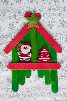 a christmas decoration made out of popsicle sticks with santa clause on top and trees