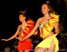 two women in colorful costumes are dancing on stage