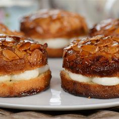 several pastries are on a plate with some frosting and nuts in the middle