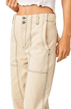 These classic cotton carpenter pants feature pronounced topstitching and wide legs. 26" inseam; 20" leg opening; 13 1/2" front rise; 17" back rise (size 8) 100% cotton Dry clean or machine wash, tumble dry Imported Gathered Top, Contrast Topstitching, Beige Jeans, Utilitarian Style, Jean Crafts, Carpenter Pants, Mid Rise Jeans, Sheer Sleeves, Ulla Johnson