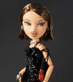 a close up of a doll wearing a black dress