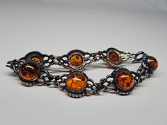 This vintage cabochon sterling silver amber bracelet weighs 17.03 g. The length is 7 inches long. There are 7 double link cabochon amber. On the back side of each cabochon amber link it is marked 925 and V-8. It is tarnished. It has a spring ring clasp.  Each item listed will be clean with soap and water. Some sterling may be polished. Everything listed is the best of my knowledge. Feel free to reach out to me with any questions or concerns. Vintage Sterling Silver Cabochon Bracelets, Vintage Sterling Silver Bracelets With Cabochon, Adjustable Amber Bracelet For Formal Occasions, Vintage Cabochon Bracelets For Formal Occasions, Vintage Baltic Amber Jewelry For Formal Occasions, Formal Round Baltic Amber Jewelry, Adjustable Amber Jewelry For Formal Occasions, Formal Baltic Amber Jewelry, Formal Baltic Amber Cabochon Jewelry