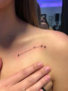 a woman's chest with the word love written in small stars on her left side