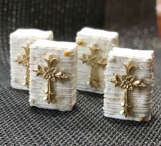 three small white candles with gold crosses on them