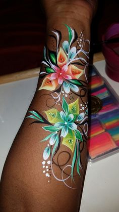 a woman's arm with flowers painted on it