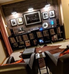 a living room filled with lots of furniture and pictures on the wall above it's bookshelves