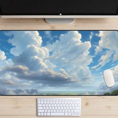 a computer desk with a keyboard and mouse on it, under a cloudy blue sky