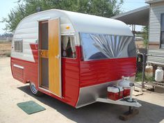 a red and white trailer parked in front of a house