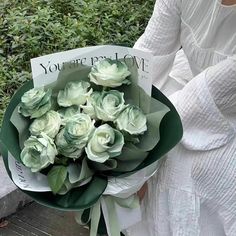 a woman holding a bouquet of white roses