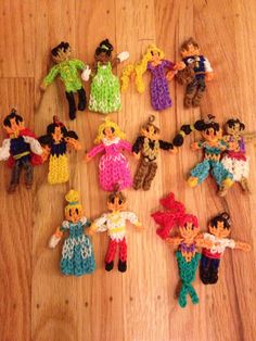 many small crocheted dolls are arranged on the wooden floor, with one doll standing out from the others