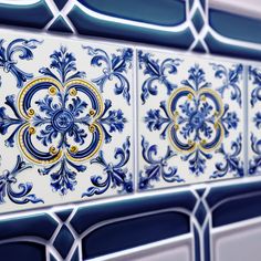 blue and white tiles with gold designs on them