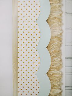 a white and yellow wall hanging with polka dots on it