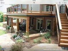 an image of a deck with stairs and patio furniture in the back yard, as well as steps leading up to the second floor