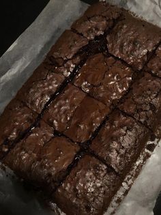 a chocolate brownie sitting on top of a piece of wax paper