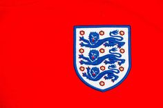 the england crest is displayed on a red shirt