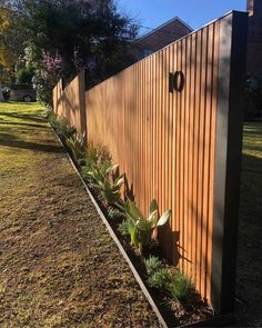 a wooden fence with succulents growing on the side and in between it