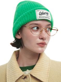 a woman wearing glasses and a green hat