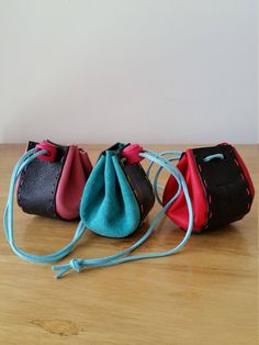 three small purses sitting on top of a wooden table