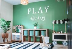 a play room with green walls and white furniture