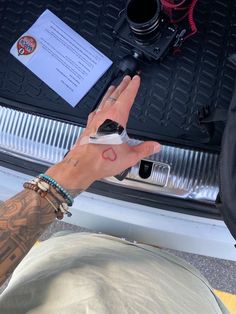 a person holding their cell phone in the trunk of a car