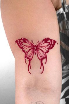 a woman's arm with a red butterfly tattoo on the left side of her body