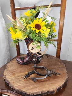 a wooden table topped with a vase filled with yellow flowers and a pair of cowboy boots