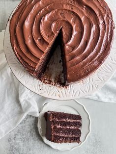 a chocolate cake on a plate with one slice cut out and the rest half eaten