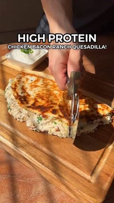 a person cutting up food on top of a wooden cutting board