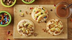 three desserts on a cutting board with candy and candies