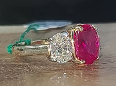 an image of two rings with diamonds and pink stones on the top one is yellow gold