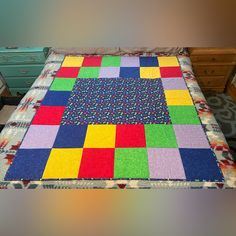 a multicolored patchwork quilt sitting on top of a dresser