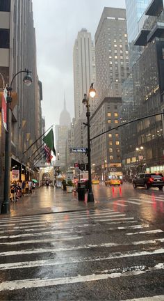 a city street with cars and people on it in the rain