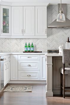 a kitchen with white cabinets and wooden floors